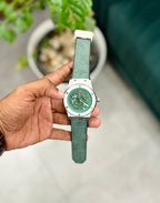a watch with a green strap and silver case, 