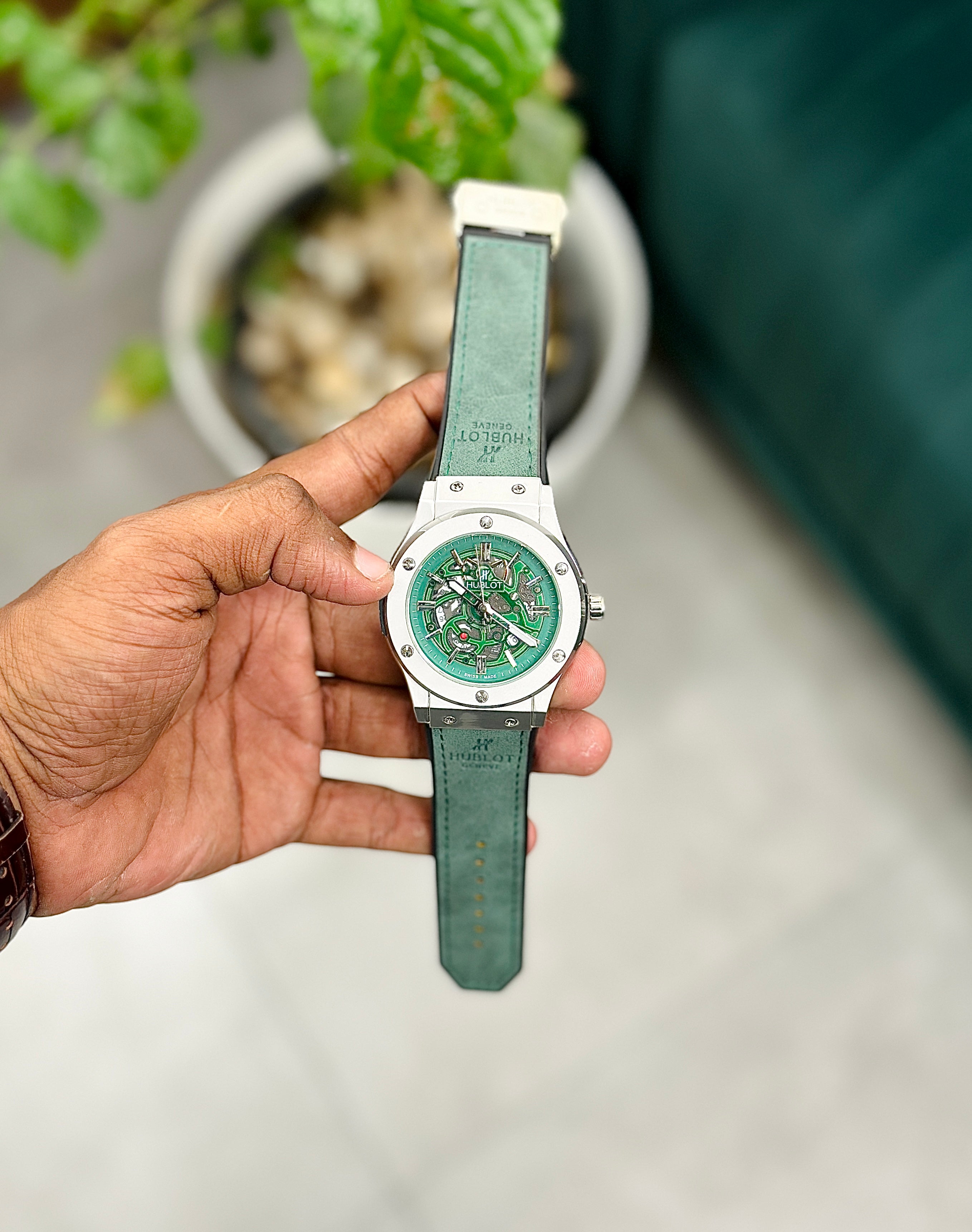 a watch with a green strap and silver case, 