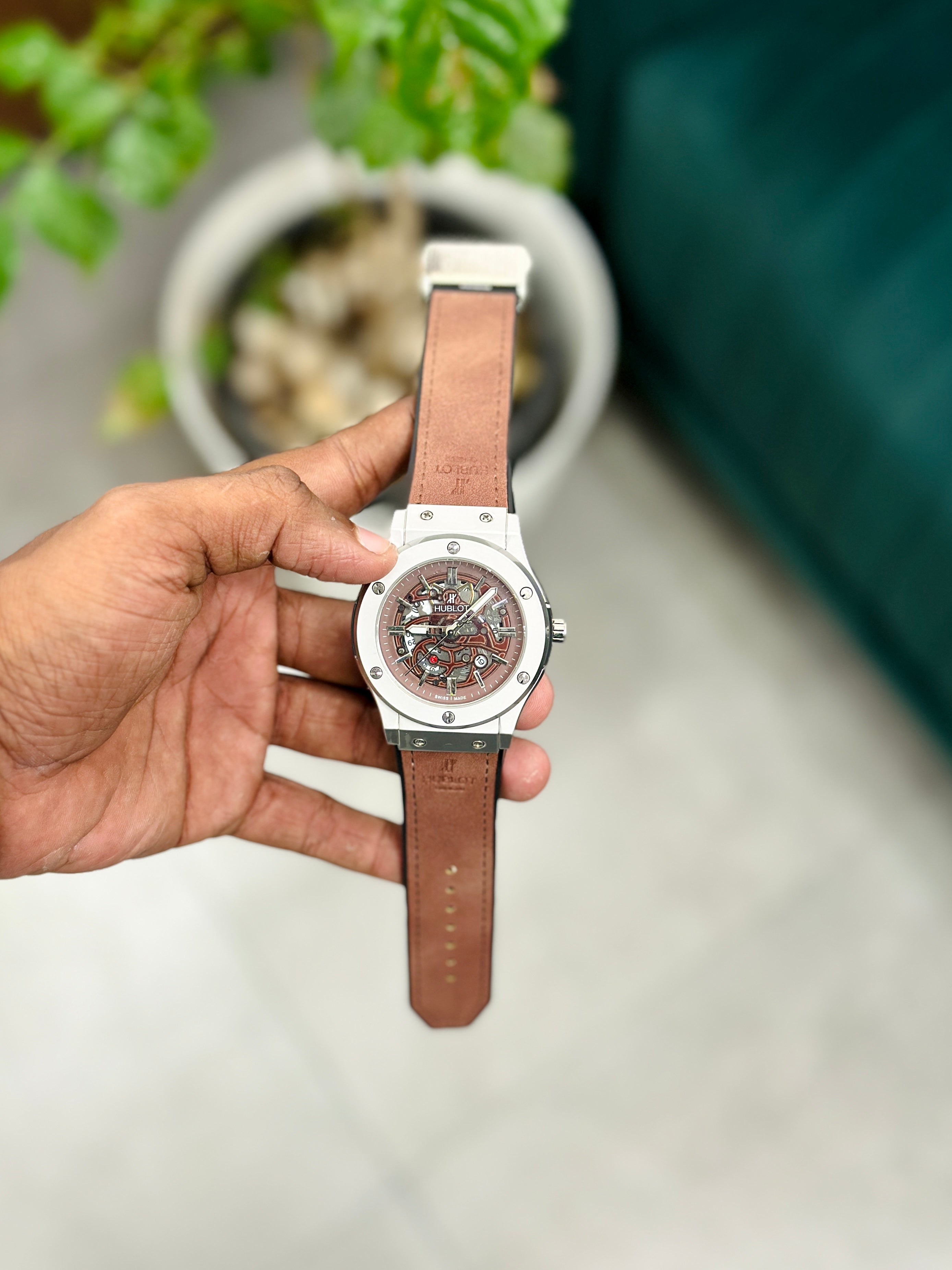  a watch with a brown strap and silver case 